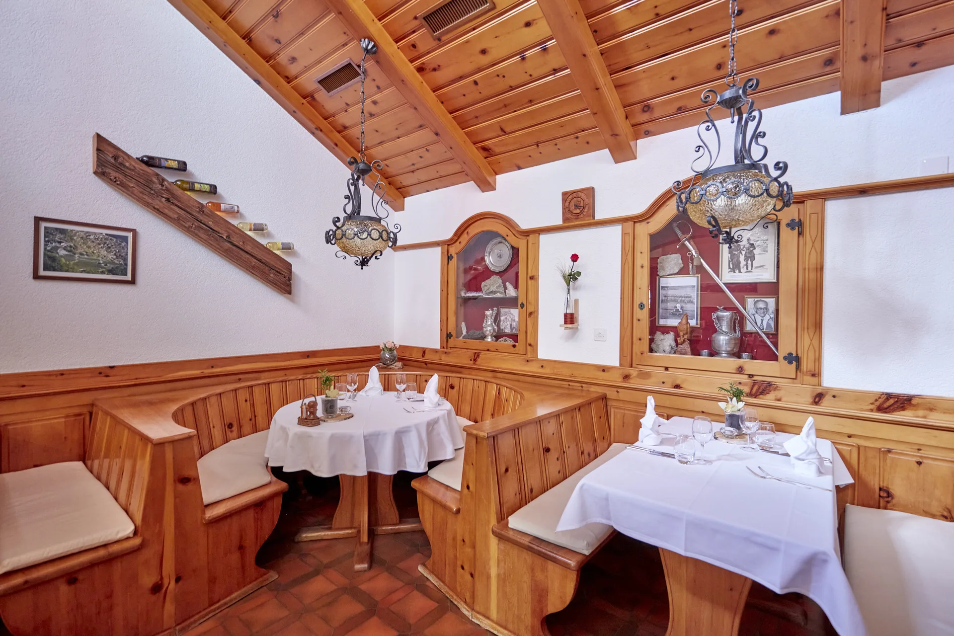 Gemütliches Alpenrestaurant mit Holznischen, weissen Tischdecken und Kronleuchtern