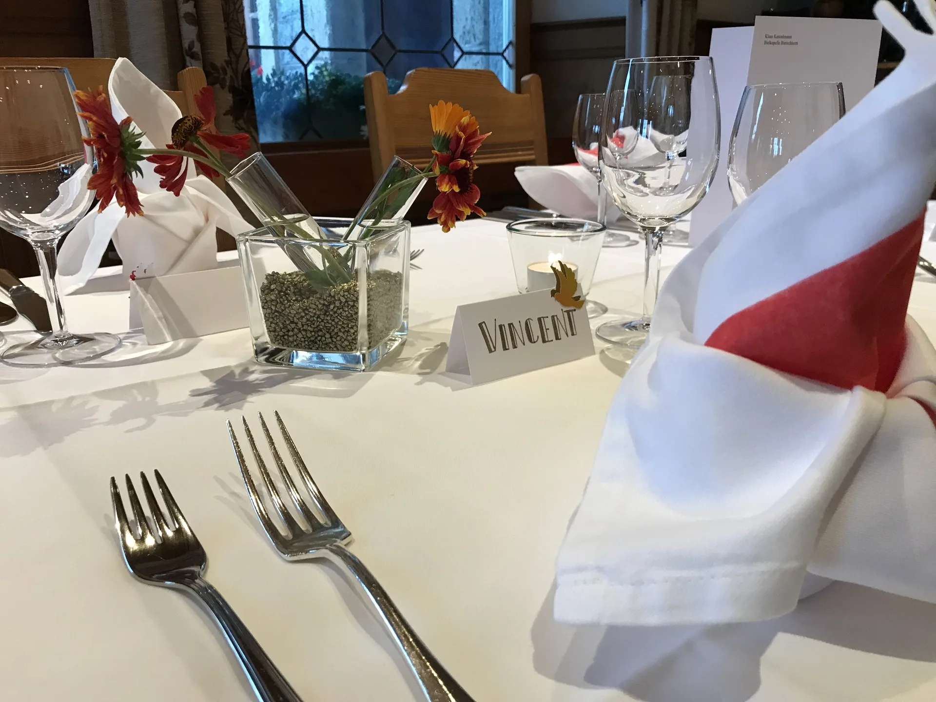 Festlich gedeckter Tisch mit Weingläsern und frischen Blumen im Restaurant Alpenblick